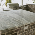 A flowing pattern of pewter, golden, and cocoa tones.